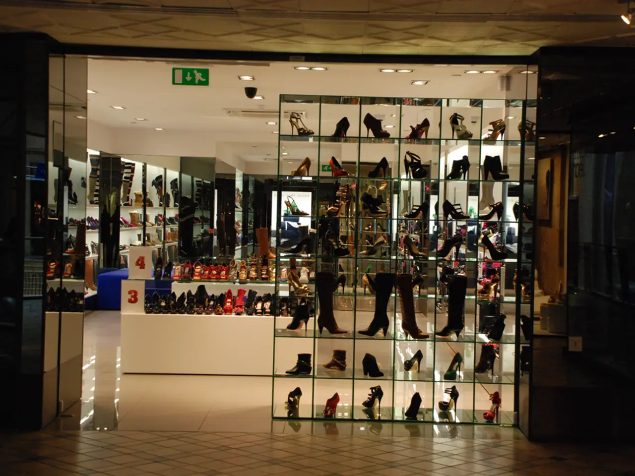 In this picture, we see many shoes are displayed. Behind that, we see a white table on which shoes...
