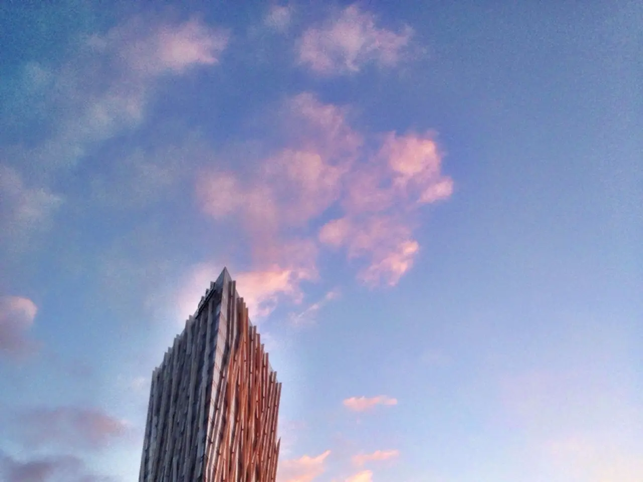 This image consists of a skyscraper and many buildings. To the right, there is a hoarding. At the...