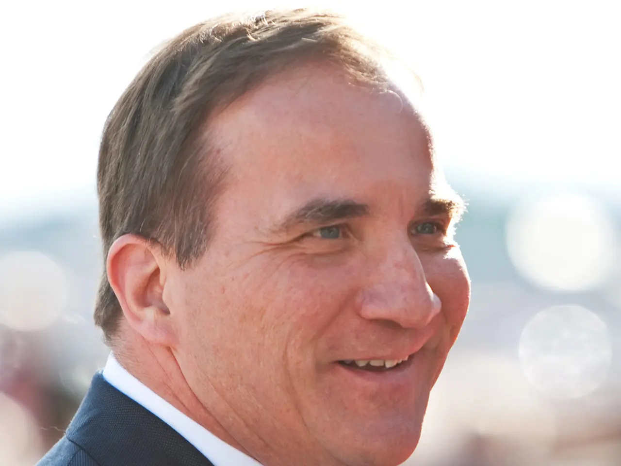 In the image I can see a person is wearing a blazer and smiling.