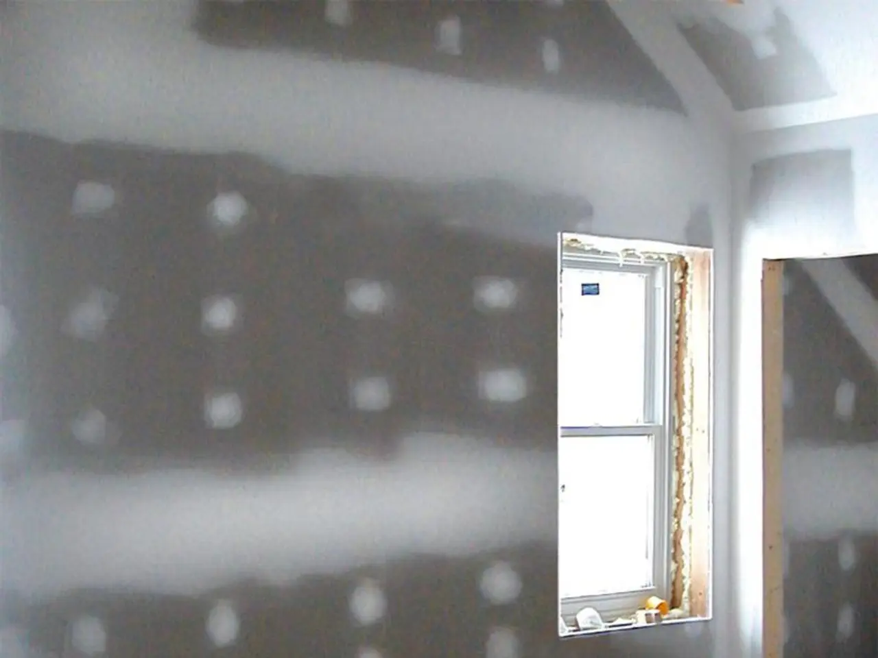 In this image there is a glass window on the wall, beside the window there is an entrance to...