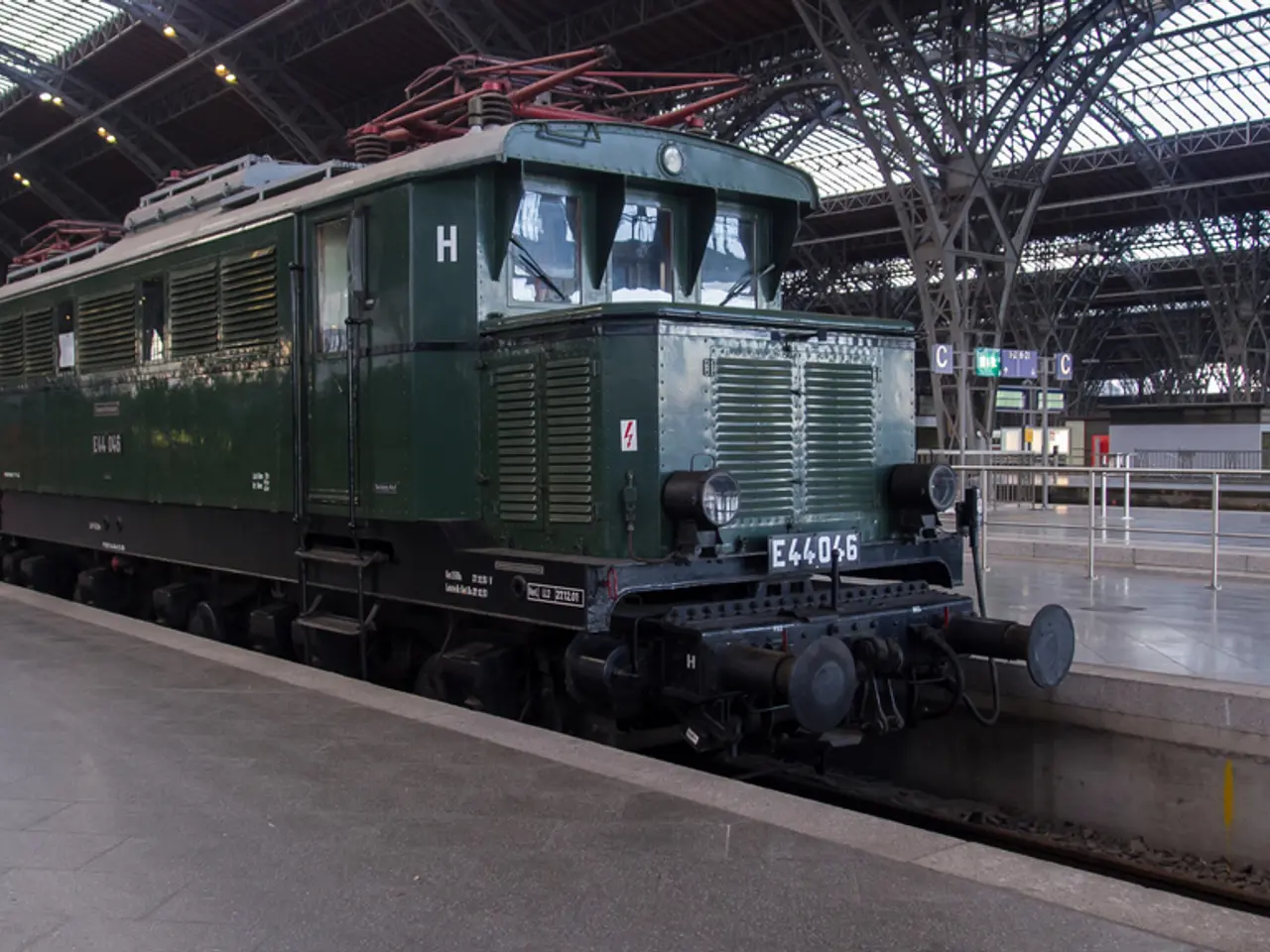 In this picture there is a train on the railway track. At the back there are boards and there are...
