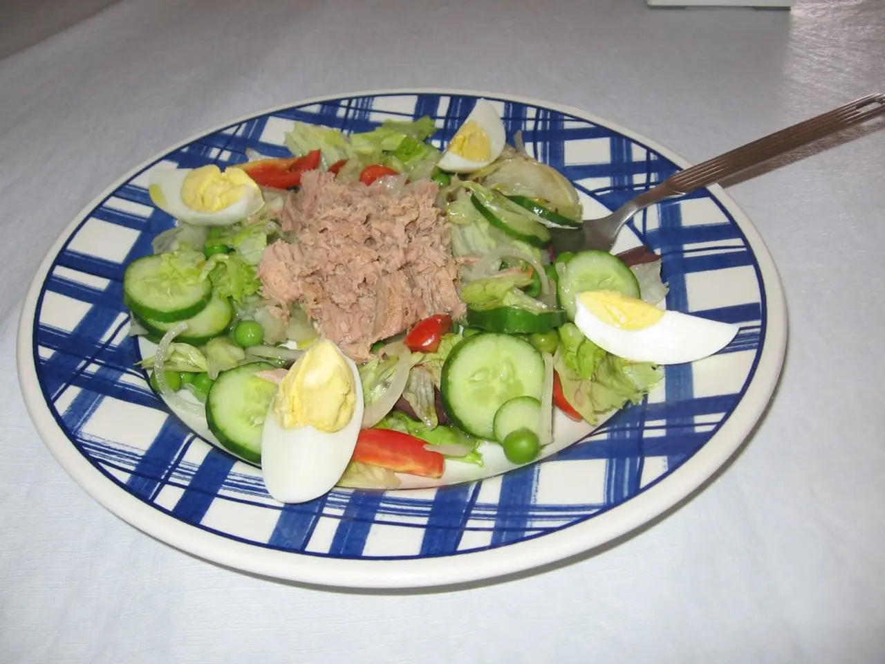 There is a plate on a white surface. On the plate there is a food item and fork. On the food item...