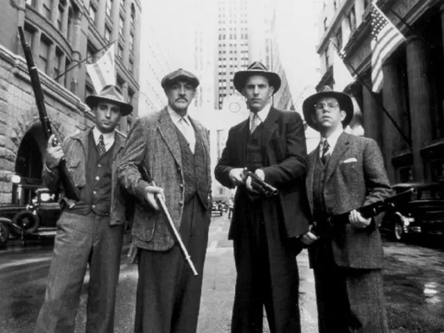In this picture we can see four men are standing and holding guns, on the right side and left side...