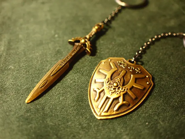 In this image we can see a sword keychain and another keychain on which a logo is there.