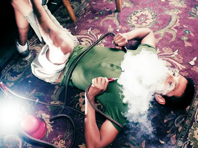 In this picture we can see the boy wearing green t-shirt, lying on the red carpet and smoking...