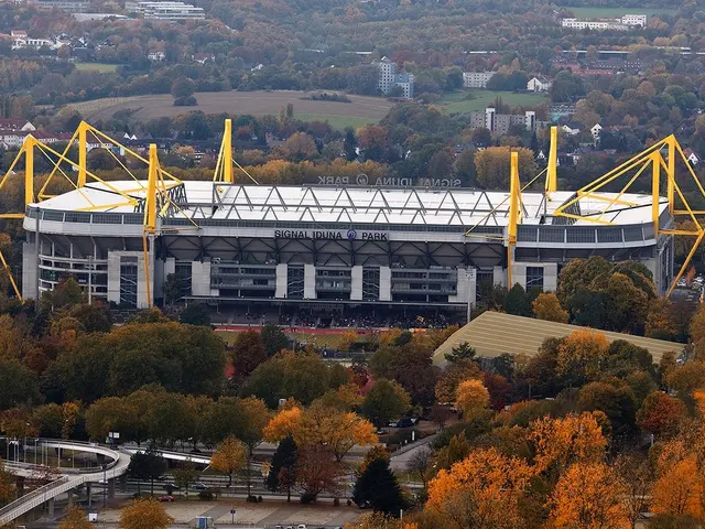 In the foreground of this image, there are many trees, fly over, road and vehicles moving on the...